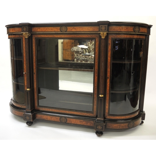 Victorian ebonised and amboyna banded credenza, the moulded top above a central glazed panel door enclosing shelves flanked by two bow glazed doors on bun feet, 166cm wide