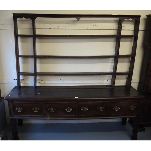 1165 - 18th Century oak dresser, the open shelved back above a moulded top with four short drawers, having ... 