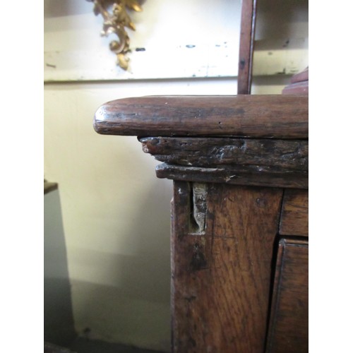 1165 - 18th Century oak dresser, the open shelved back above a moulded top with four short drawers, having ... 