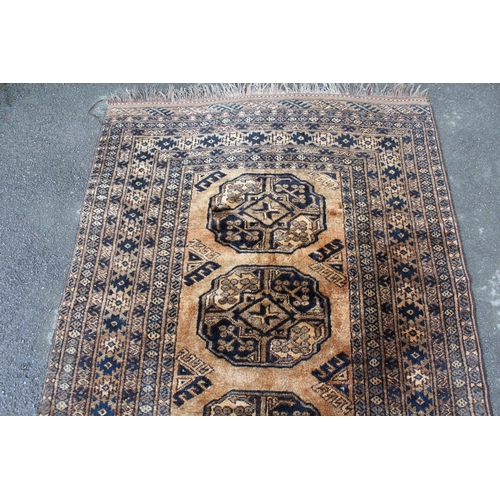 16 - Afghan gold ground rug with three gols and multiple borders, 190 x 133cm approximately