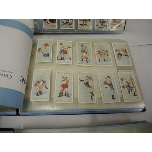 335 - Group of three red cigarette card albums, physical culture, wrestling, first aid, mainly by Wills ci... 