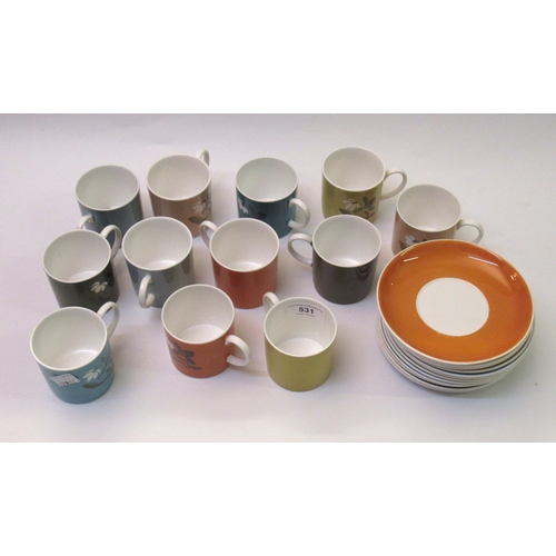 531 - Collection of Susie Cooper coffee cups and saucers of various colours with floral decoration