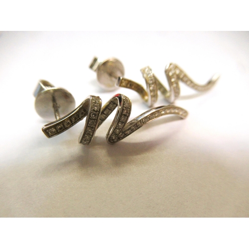 Pair of white metal drop earrings set with diamonds