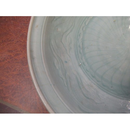 369 - Chinese Celadon circular deep dish with shallow incised decoration, 32cm diameter, with a hardwood s... 