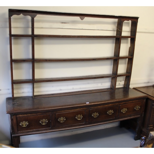 1402 - 18th Century oak dresser, the open shelved back above a moulded top with four short drawers, having ... 