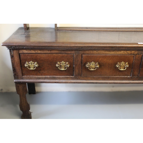 1402 - 18th Century oak dresser, the open shelved back above a moulded top with four short drawers, having ... 