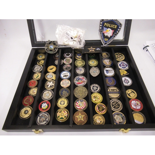 108 - Collection of American Police Department medallions, housed in an ebonised wall cabinet