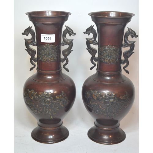 1091 - Pair of Japanese brown patinated bronze two handled vases with relief moulded bird and floral decora... 