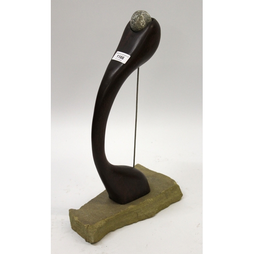 1166 - Martin Cundell, carved hardwood sculpture, ' Holding Stone ', circa 1989, on stone base, 45cm high  ... 