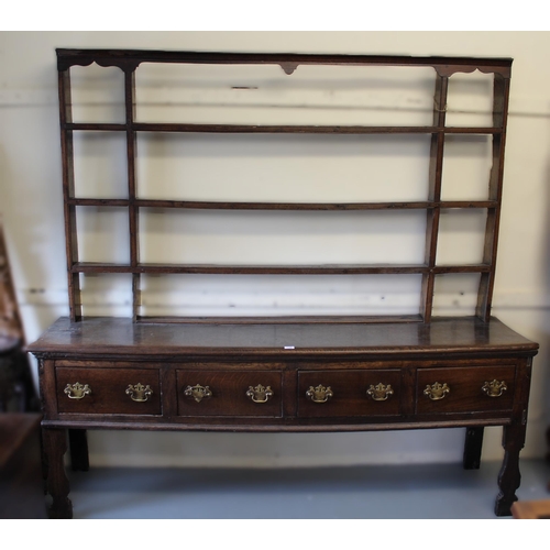 1185 - 18th Century oak dresser, the open shelved back above a moulded top with four short drawers, having ... 