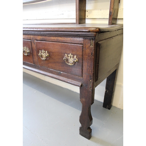 1185 - 18th Century oak dresser, the open shelved back above a moulded top with four short drawers, having ... 