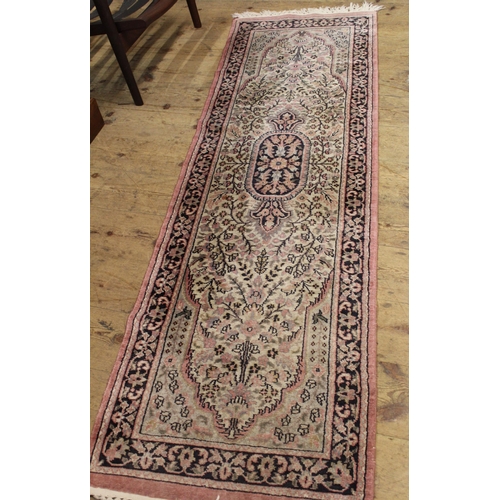 12 - Indian rug with a medallion and all-over floral design on a rose ground with borders, together with ... 