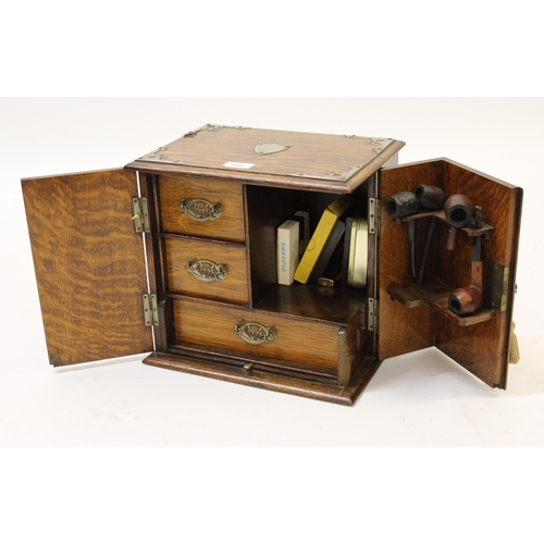 1452 - Early 20th Century oak two door smokers compendium, with silver plated mounts