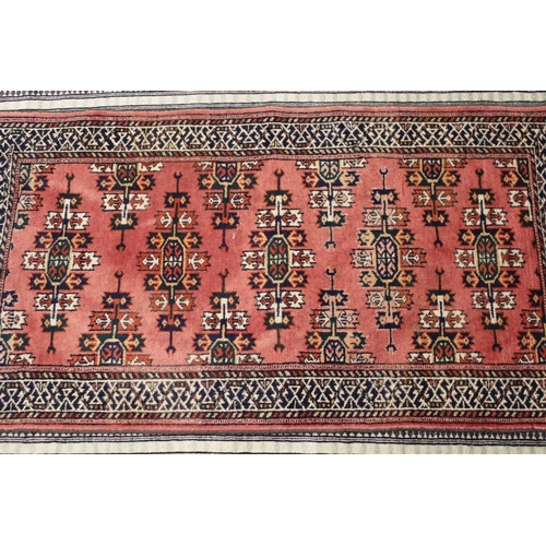 2 - Pakistan Bokhara rug with typical repeating gol design on a terracotta ground, 180 x 130cm, together... 