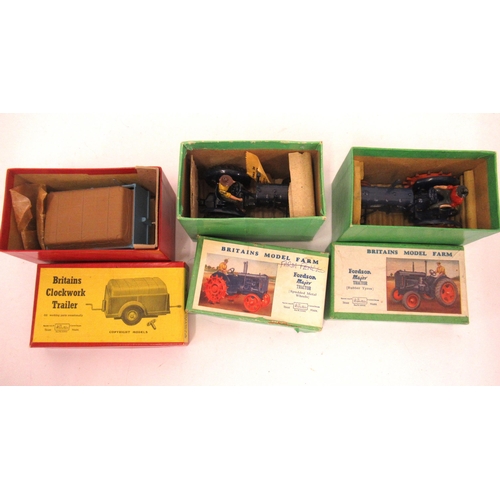 Two Britains model farm Fordson Major tractors in original boxes, together with a Britains clockwork trailor