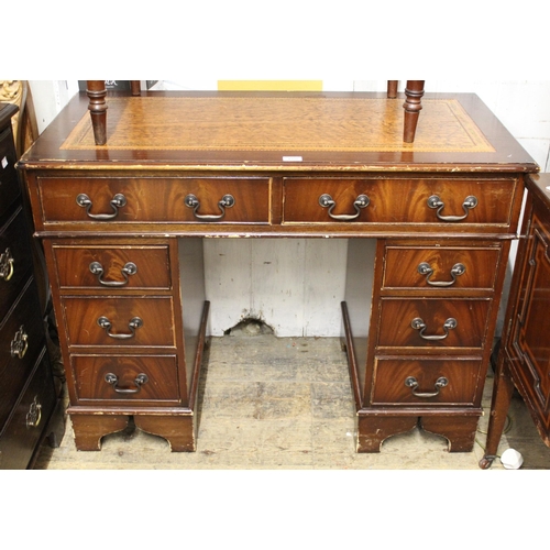Reproduction mahogany twin pedestal desk with leather inset top and nine drawers, 77cm high x 107cm wide x 54cm deep, together with a circular occasional table (at fault), and an oval metal framed 1920's wall mirror with bevelled plate