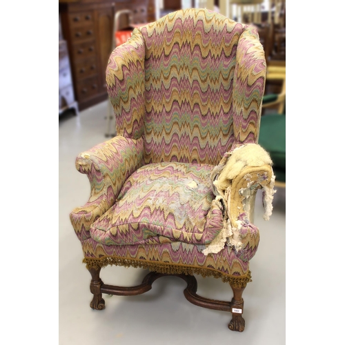 19th Century wingback armchair, in Carolean style on shaped supports with crossover stretcher (for re-upholstery), 123cm high x 83cm wide x 80cm deep
