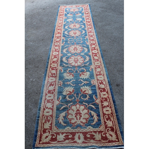 16 - Indo Persian runner with a repeating palmette design on a mottled blue ground with borders, 380 x 85... 