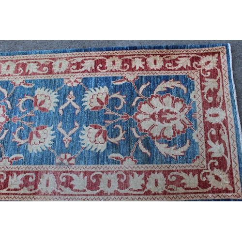 16 - Indo Persian runner with a repeating palmette design on a mottled blue ground with borders, 380 x 85... 