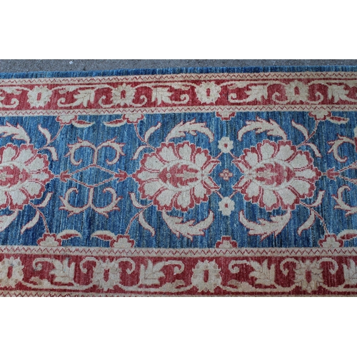 16 - Indo Persian runner with a repeating palmette design on a mottled blue ground with borders, 380 x 85... 