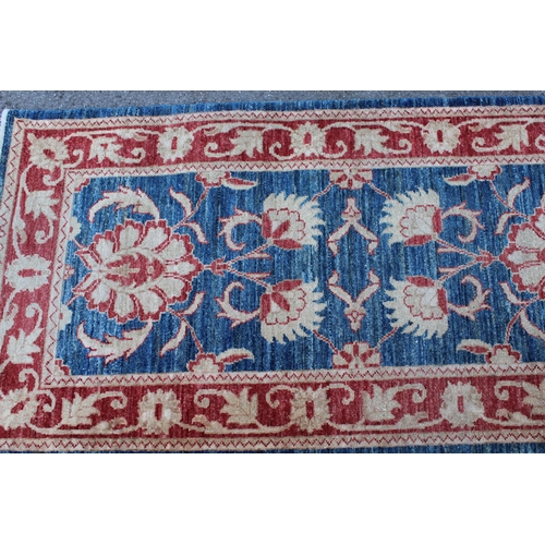 16 - Indo Persian runner with a repeating palmette design on a mottled blue ground with borders, 380 x 85... 