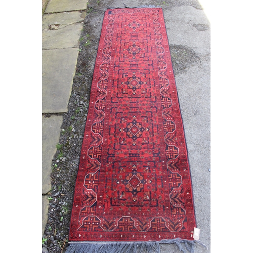 20 - Mid 20th Century Pakistan Belouch runner with a four medallion design on a red ground