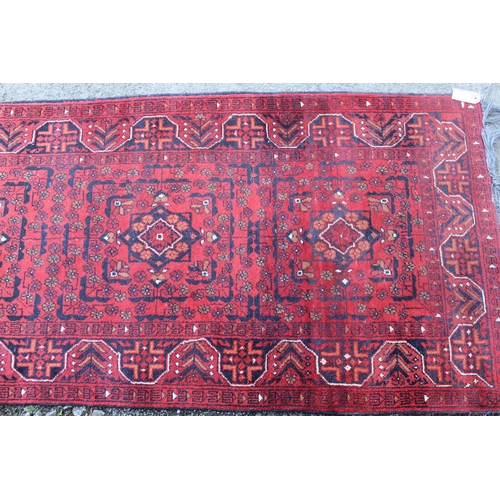 20 - Mid 20th Century Pakistan Belouch runner with a four medallion design on a red ground