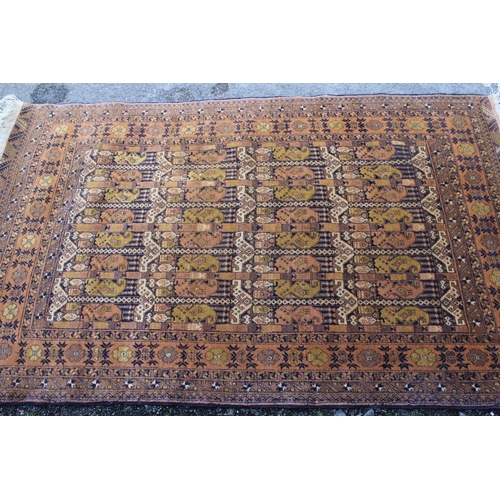 22 - Belouch rug with all-over floral and geometric design, with floral borders on a rust ground, 210 x 1... 