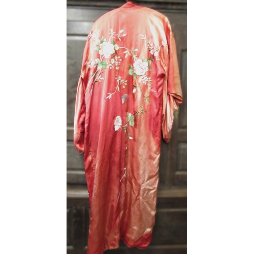 31 - Chinese red silk kimono with embroidered floral decoration, together with a hat (sun damaged)