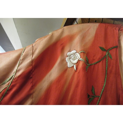 31 - Chinese red silk kimono with embroidered floral decoration, together with a hat (sun damaged)