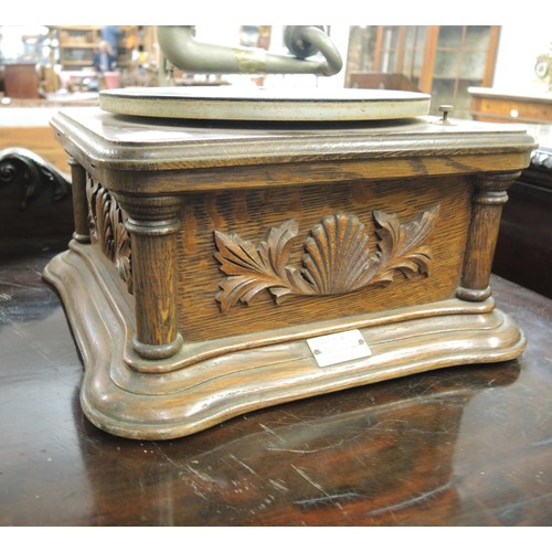 410 - Oak cased table model wind-up gramophone with large toleware horn, with decorative carved oak case i... 