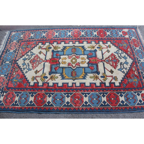 10 - Kazak rug having all-over geometric design with borders on a red, blue and cream ground, 1.5m x 2.3m