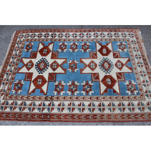 12 - Kazak rug having two hooked medallions on a cream and pale blue ground with multiple borders, 1.5 x ... 