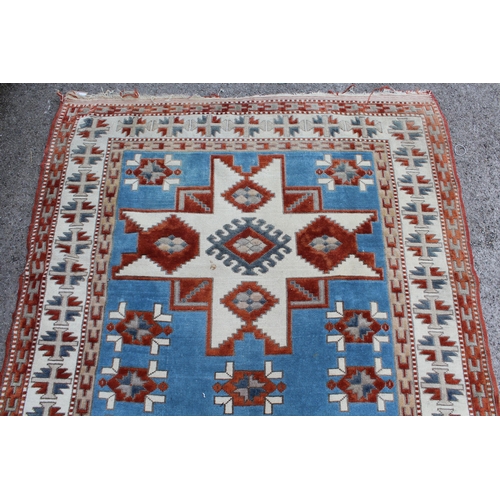 12 - Kazak rug having two hooked medallions on a cream and pale blue ground with multiple borders, 1.5 x ... 