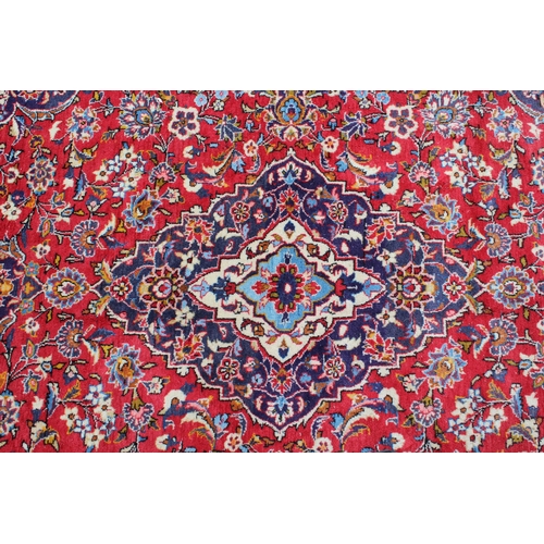 14 - Modern Kashan carpet with all-over floral decoration on a red ground with multiple borders