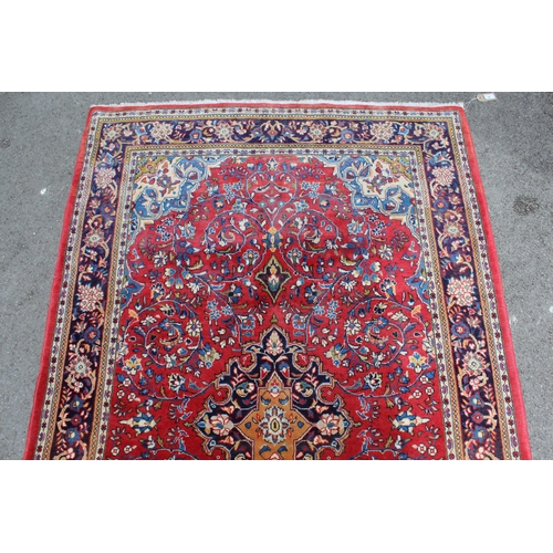 16 - Modern Kashan rug, with all-over floral design on red ground with borders