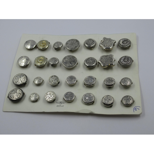 790 - Fourteen pairs of silver bachelors buttons mounted on a card