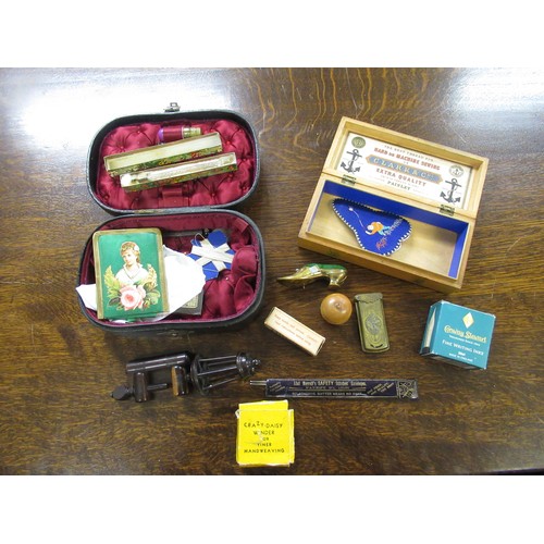 181 - Leather casket containing various needlework items including a rosewood table clamp, a tape measure ... 