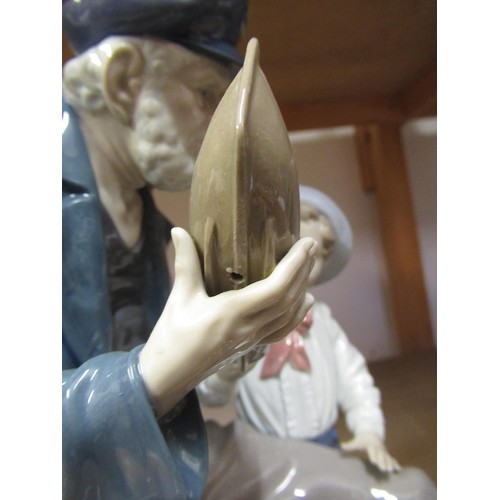 600 - Lladro group of a sailor, boy and model boat, 28cm high