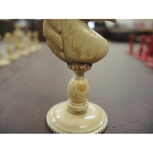 108 - 19th Century carved bone natural and red stained chess set, in later box