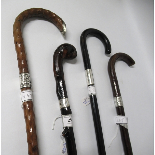 259 - Two knobbly shafted silver mounted walking canes, another similar and an ebony silver collared walki... 