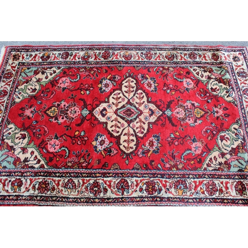 13 - Hamadan rug with a medallion and stylised floral design on a red ground with borders, 200 x 125cm