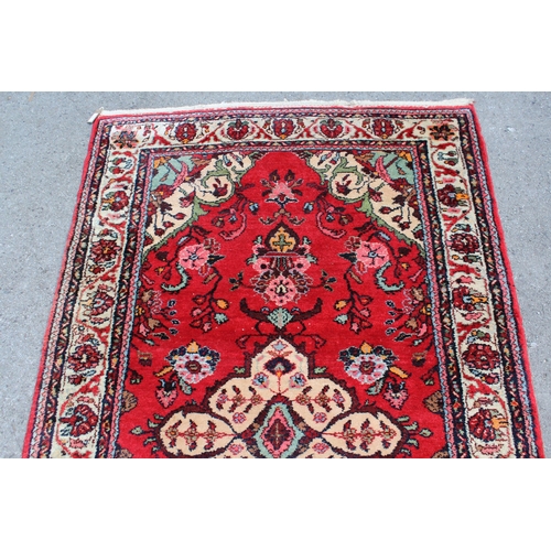 13 - Hamadan rug with a medallion and stylised floral design on a red ground with borders, 200 x 125cm