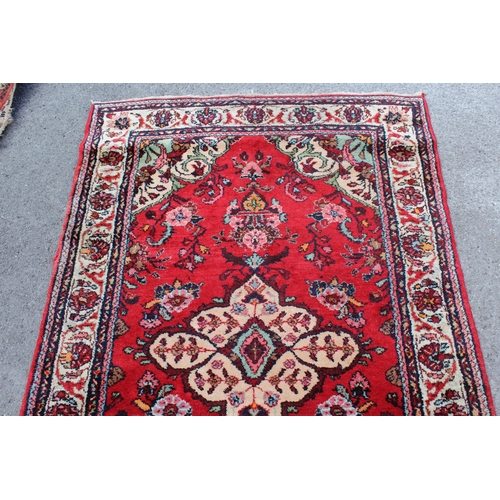 13 - Hamadan rug with a medallion and stylised floral design on a red ground with borders, 200 x 125cm