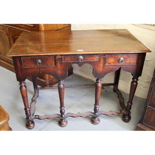 1687 - 18th Century oak side table, having an arrangement of three short drawers with brass ring handles on... 