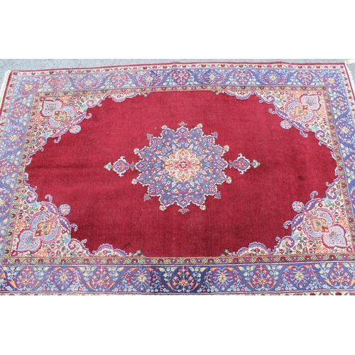 17 - Tabriz rug with centre medallion and multiple borders on a burgundy ground, 193 x 126cm