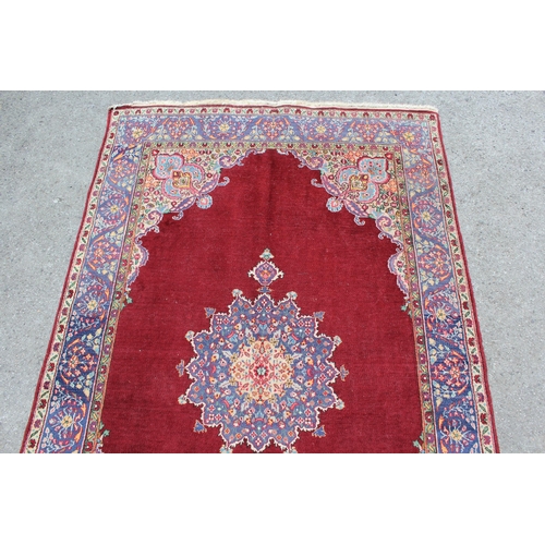 17 - Tabriz rug with centre medallion and multiple borders on a burgundy ground, 193 x 126cm