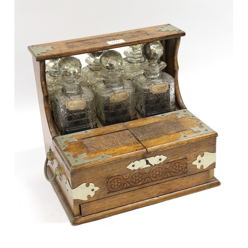 1717 - Victorian oak three bottle tantalus with silver plated mounts