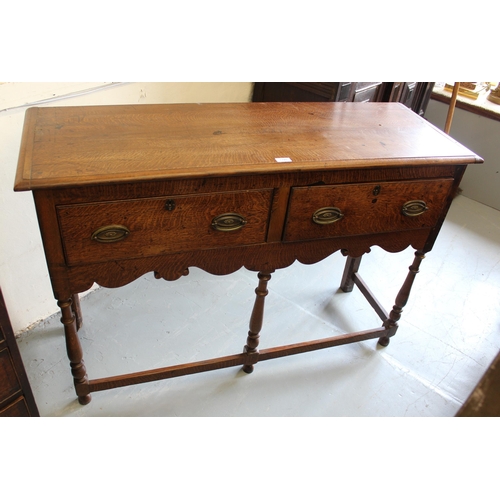 1740 - Small oak dresser base, the moulded top above two short drawers with oval brass handles and turned s... 