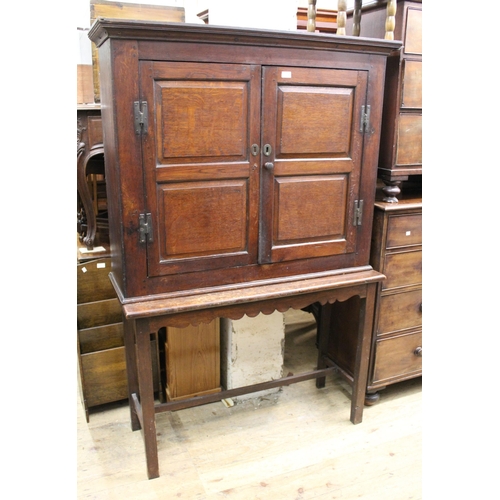 1762 - 18th Century oak bookcase with two panelled doors enclosing shelved interior, on an associated later... 